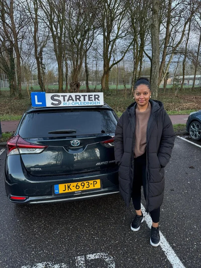 Leerling bij de lesauto na een autorijles in Den Haag